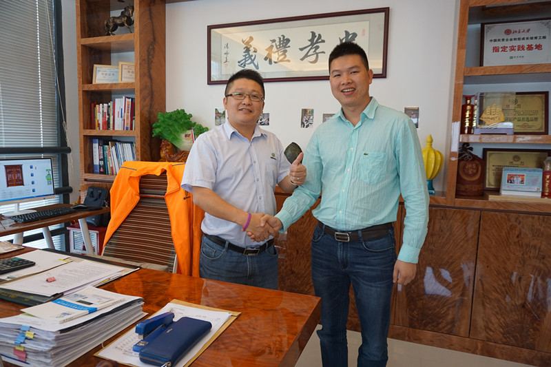 漆強(qiáng)化工張文（左）熱烈歡迎廣東門業(yè)市場(chǎng)總監(jiān)饒德亮（右）.jpg